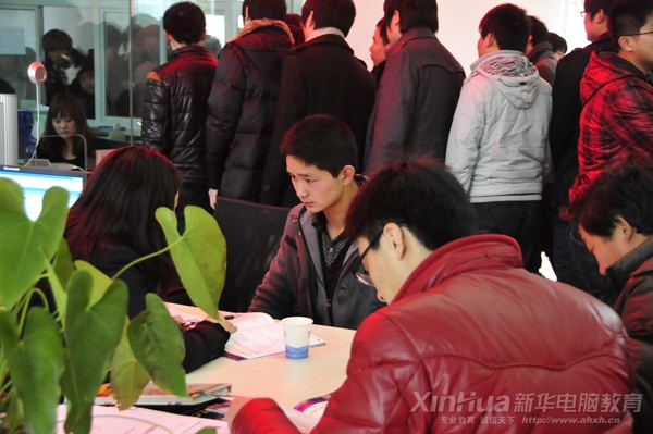 新華咨詢中心內(nèi),男孩專注地聽老師介紹專業(yè)